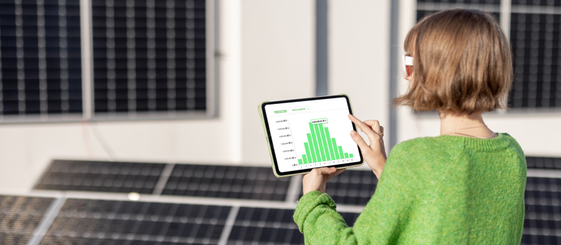 a woman holding a tablet surrounded by solar panels